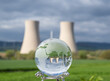 glass earth globe against nuclear power plant