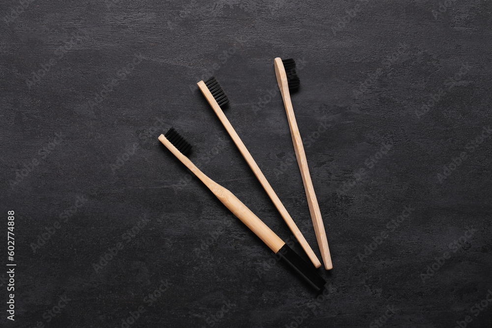 Bamboo toothbrushes on grunge black background