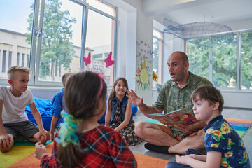 Sticker - Reading time in an elementary school or kindergarten, a teacher reading a book to children in an elementary school or kindergarten. The concept of pre-school education. Selective focus