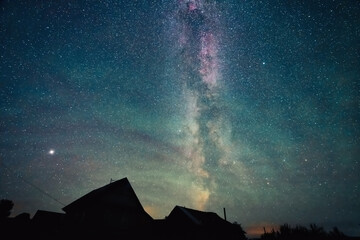 Wall Mural - stars sky and milky way above roofs in countryside