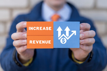 Man holding colorful blocks with icons and inscription: INCREASE REVENUE. Concept of growth hacking and increase revenue marketing business technology. Increase number of users and revenues.