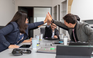 business hispanic milti ethnic group people making hi five to cheer teamwork for success at the office or meeting room; smiling boss celebrating with employees workers