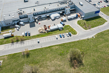 Poster - aerial view of trucks unloading goods at shopping mall. drone photo from above.