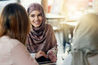 © Adene Sanchez/peopleimages.com - Friends, happy and Muslim women in cafe, bonding and talking together. Coffee shop, smile and Islamic girls, group or people chat, conversation and discussion for social gathering in restaurant.