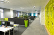 © Wavebreak Media - Interior of modern office with desks, plant and patterned wall, copy space
