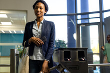 African American Female Professional Entering From Turnstile Gate In Office, Copy Space