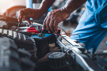 Wall Mural - A multimeter voltmeter is used by auto mechanics to measure the voltage of a car battery.