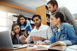 © K Seisa/peopleimages.com - Computer, talking and students studying in a library for a group project, teamwork and education. Learning, laptop and friends speaking about university notes, knowledge and planning research