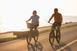 Couple taking pleasure in the ride on beach cruiser bikes, pedaling on a wonderful route near the sea
