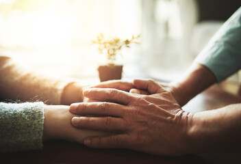 Holding hands, senior couple and retirement support with kindness and marriage. Home, sofa and elderly people with empathy, hope and trust with solidarity for finance problem in a lounge together