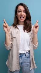 Wall Mural - pretty young brunette female adult in casual shirt crossed her fingers