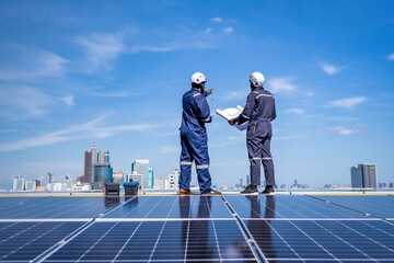 engineers walking on roof inspect and check solar cell panel by hold blue print and tablet ,solar ce