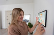 © Angelov - Controlling home with a digital touch screen panel installed on the wall in the living room. Concept of a smart home and mobile application for managing smart devices at home