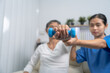 © M+Isolation+Photo - Young pretty asian physiotherapist helping senior female patient holding dumbbell in physical therapy session, concept of World Confederation for Physical Therapy.