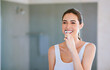 © Jadon B/peopleimages.com - Toothbrush, toothpaste and woman brushing teeth in bathroom for health, happiness and wellness in morning. Girl, cleaning mouth for dental care and oral hygiene or smile in home with mockup space