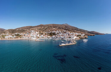 Wall Mural - Andros island Batsi Cyclades Greece. Aerial drone view of port boat, building, sandy beach sea sky.