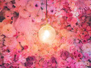 Wall Mural - light bulb over pink rose and carnation flowers bouquet background.