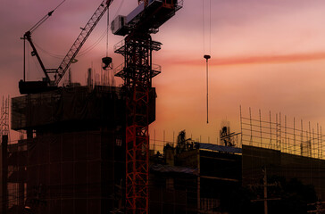 Construction crane, industrial building, construction, real estate during sunset. House infrastructure. New construction site with crane and mechanical equipment