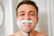 © Maria - A man shaves his face with a safety razor. The concept of men's cosmetics and shaving accessories. daily hygiene rituals.