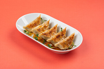 Wall Mural - Portion of japanese gyoza dumplings on pink background