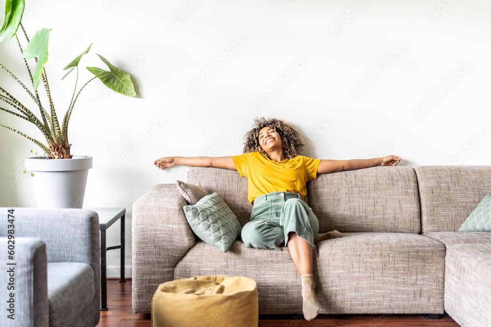 Happy afro american woman relaxing on the sofa at home - Smiling girl ...