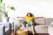 canvas print picture - Happy afro american woman relaxing on the sofa at home - Smiling girl enjoying day off lying on the couch - Healthy life style, good vibes people and new home concept