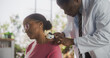 © Gorodenkoff - African Skin Care Professional Using a Dermatoscope to Examine Neck Tissue on the Skin of an Attractive Young Black Female During a Health Check Visit to a Clinic