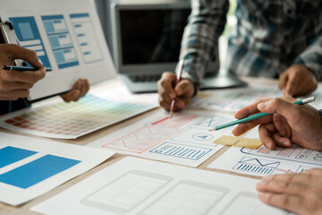 Wall Mural - group of asian creative team programing designers participate in all phases of the ux design.