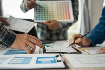 Wall Mural - group of asian creative team programing designers participate in all phases of the ux design.