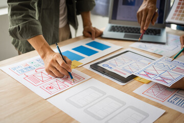 Wall Mural - group of asian creative team programing designers participate in all phases of the ux design.