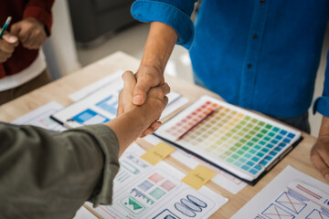 Wall Mural - shaking hands, group of asian creative team programing designers participate in all phases of the ux
