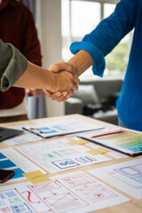 Wall Mural - shaking hands, group of asian creative team programing designers participate in all phases of the ux