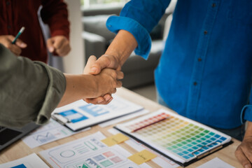 Wall Mural - shaking hands, group of asian creative team programing designers participate in all phases of the ux