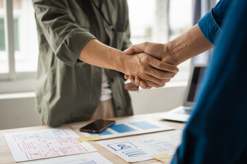 Wall Mural - shaking hands, group of asian creative team programing designers participate in all phases of the ux