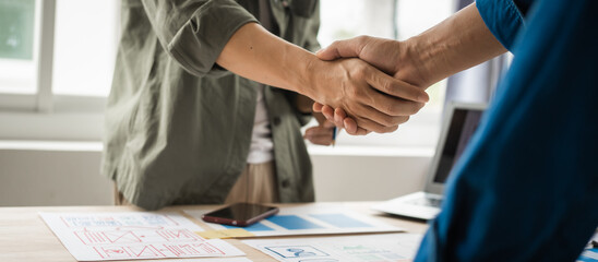 Wall Mural - shaking hands, group of asian creative team programing designers participate in all phases of the ux