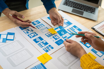 Wall Mural - group of asian creative team programing designers participate in all phases of the ux design.