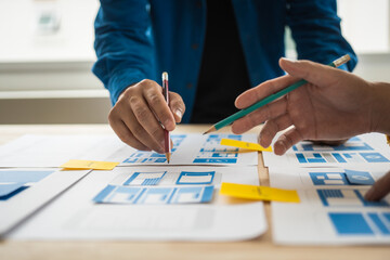 Wall Mural - group of asian creative team programing designers participate in all phases of the ux design.