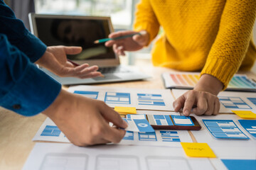 Wall Mural - group of asian creative team programing designers participate in all phases of the ux design.