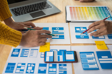 Wall Mural - group of asian creative team programing designers participate in all phases of the ux design.