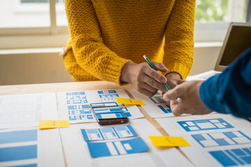 Wall Mural - group of asian creative team programing designers participate in all phases of the ux design.