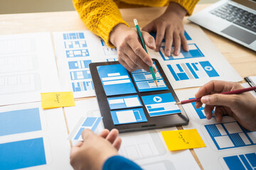 Wall Mural - group of asian creative team programing designers participate in all phases of the ux design.