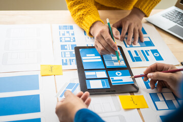 Wall Mural - group of asian creative team programing designers participate in all phases of the ux design.