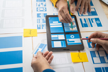 Wall Mural - group of asian creative team programing designers participate in all phases of the ux design.