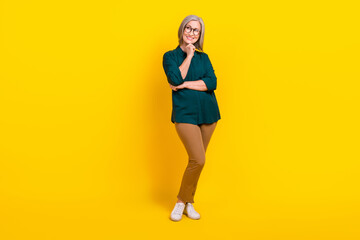 Sticker - Full body photo of creative smart aged lady arm touch chin look empty space isolated on yellow color background