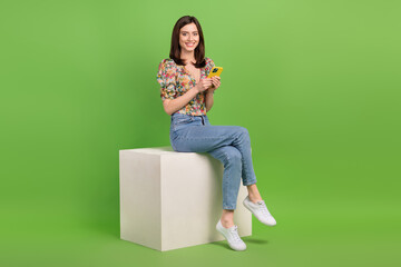 Wall Mural - full body photo of nice lovely lady sit cube podium use smart phone chatting isolated on green color