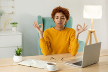 No Stress Keep Calm. Mindful African Businesswoman Practices Breathing Exercises At Home Office. Peaceful Young Woman At Workplace Enjoy Yoga Eyes Closed Hands In Chin Mudra Gesture. Office Meditation