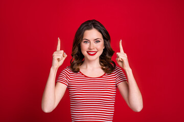 Wall Mural - Photo of cute young lady directing fingers up empty space new lipstick pomade promotion banner isolated red maroon color background