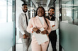 © bolaji - Young multiracial people smiling while standing at office corridor