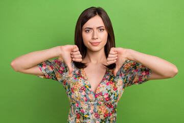 Wall Mural - portrait of unsatisfied lady two hands fingers demonstrate thumb down isolated on green color backgr