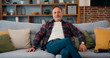 © serg - Portrait of relaxed middle eastern man looking at camera sitting on couch. Satisfied retired man with sitting on sofa at home.